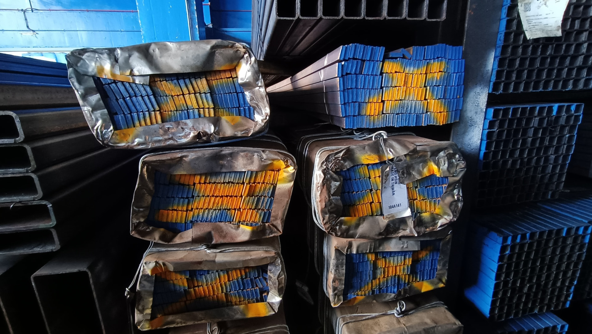 Colour-coded bundles of steel sections in storage